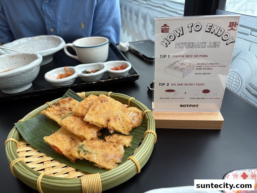 A table setting with Korean food, including pancakes and dipping sauces, and a guide on how to enjoy a dish.