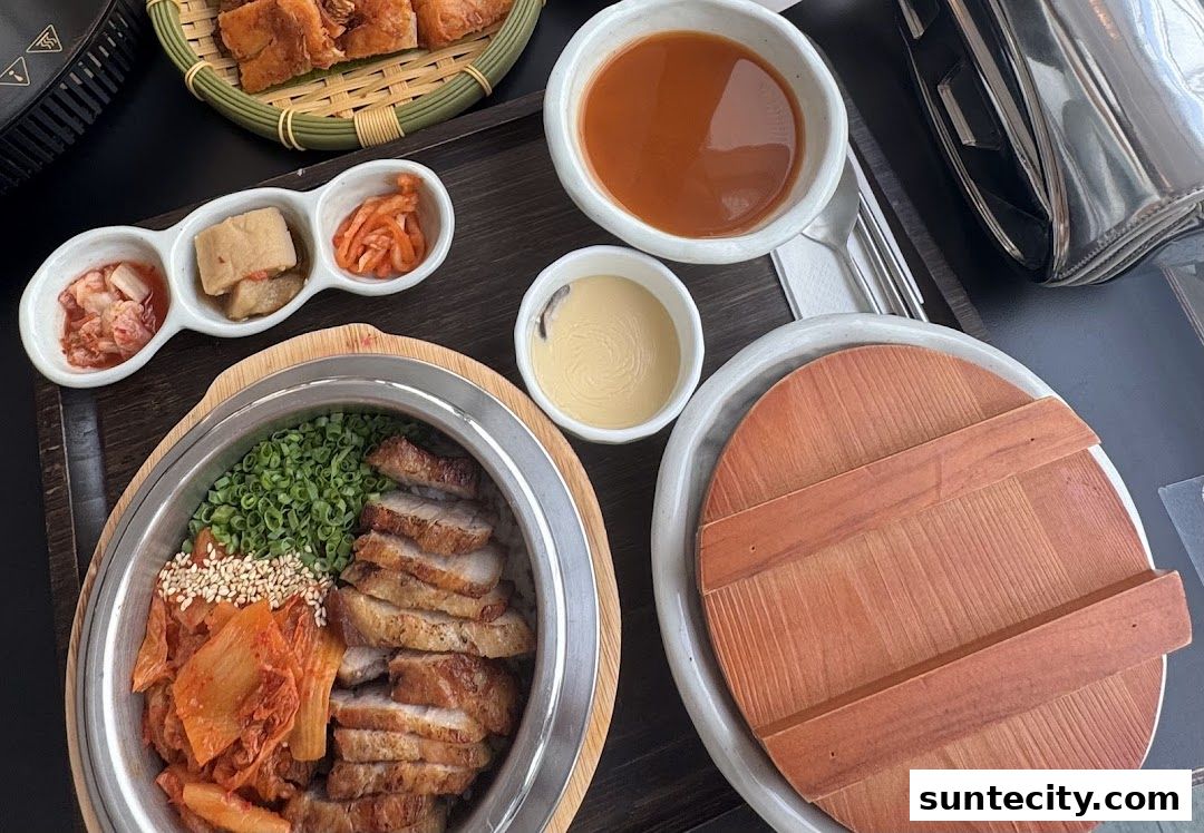 A close-up of a Korean meal with sliced pork, kimchi, and dipping sauces.
