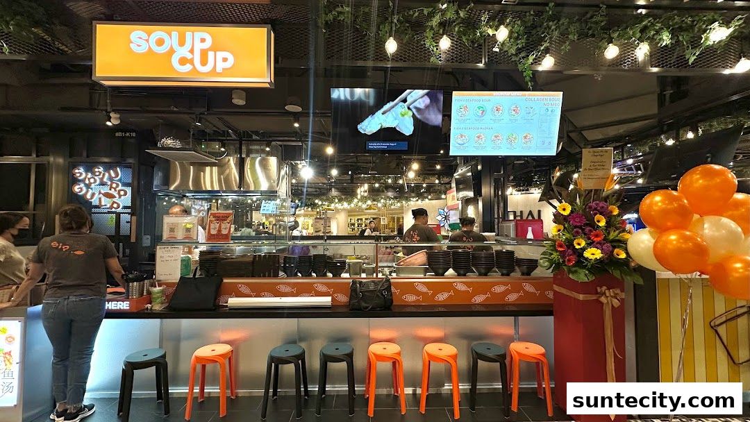 SoupCup Suntec City shop front with staff, seating, and a decorative flower arrangement.