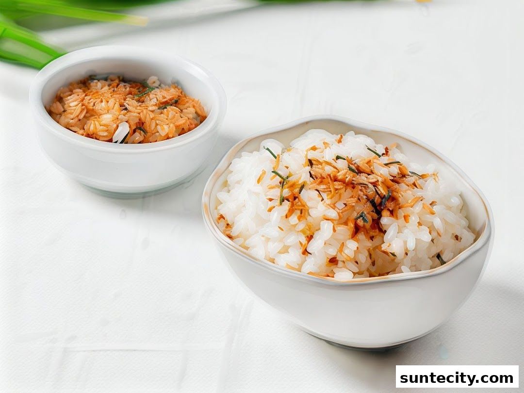Two bowls of rice, one plain and one with toppings, are presented on a white surface.