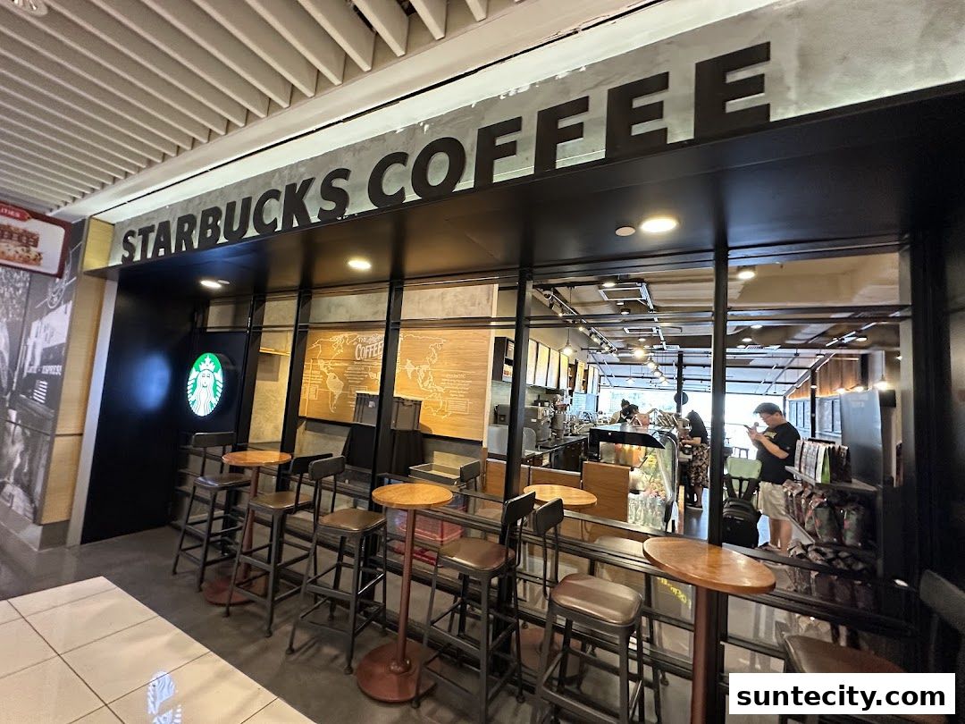 The exterior of a Starbucks coffee shop with seating and a view of the interior.