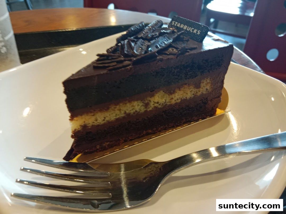 A slice of rich chocolate cake with layers and chocolate shavings on top.