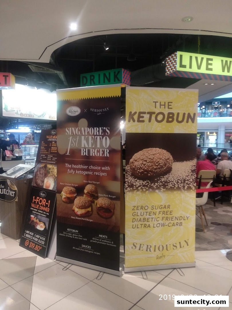 Promotional banners for keto burgers and ketobuns are displayed in a mall.