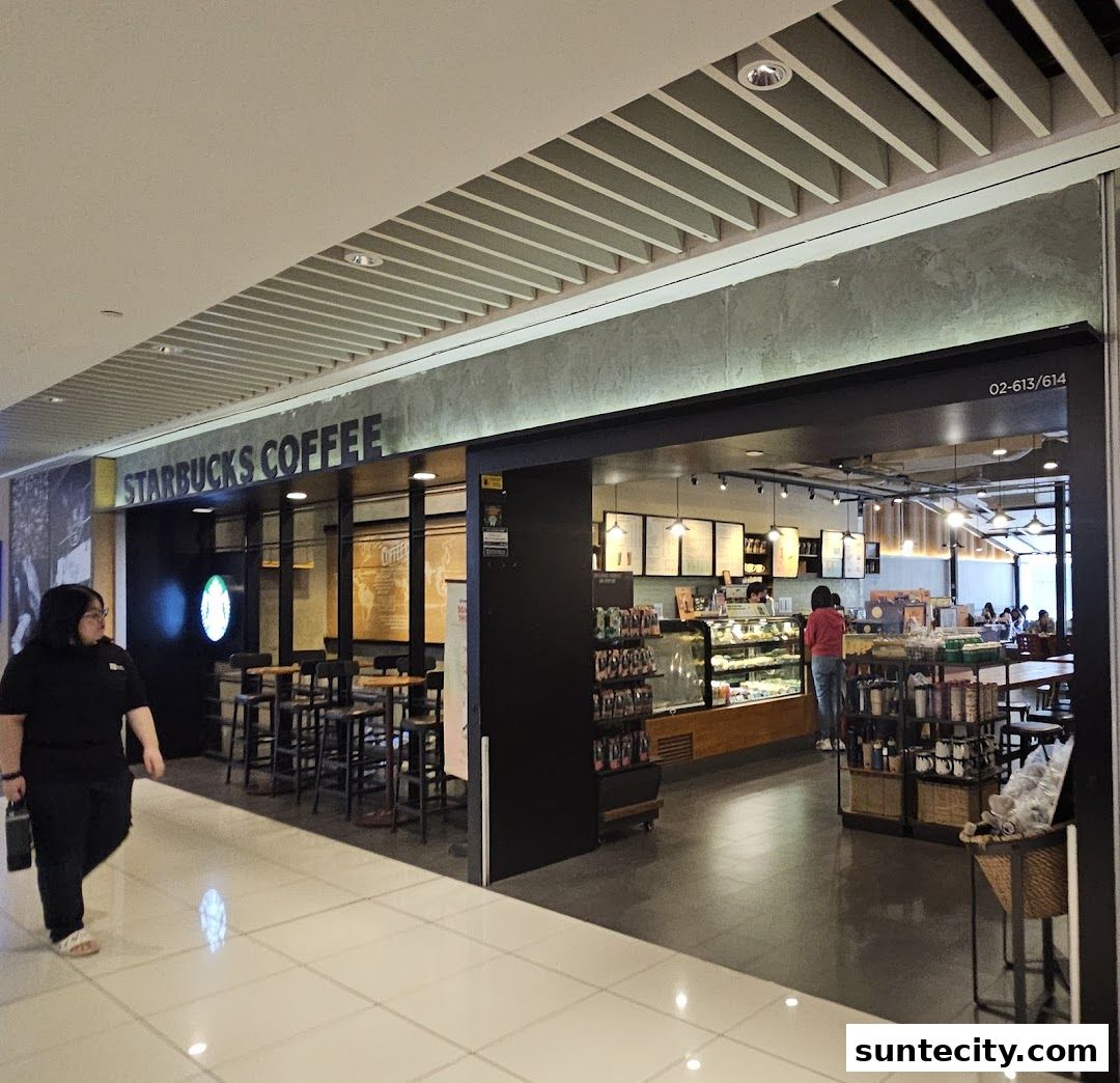 The entrance and interior of a Starbucks coffee shop with seating and display cases.