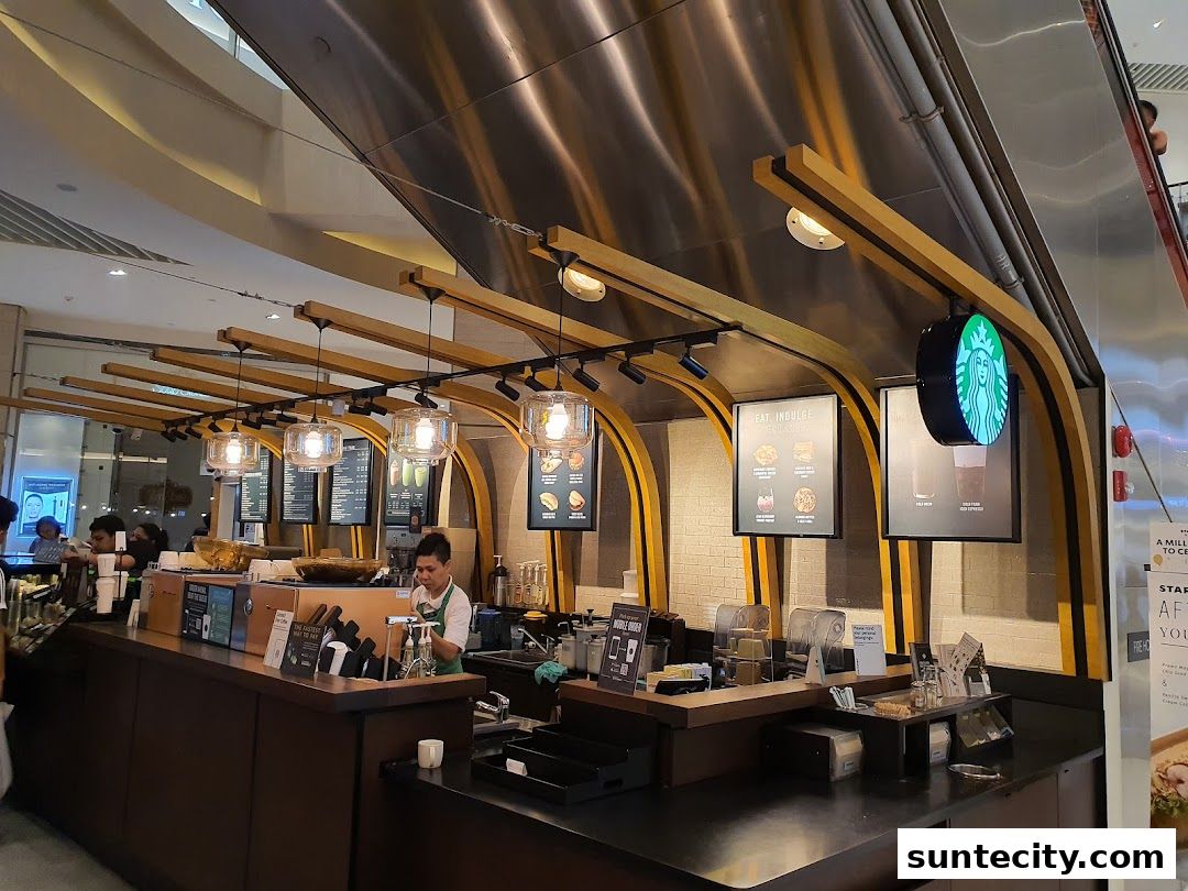 A Starbucks counter with baristas preparing drinks and customers ordering.