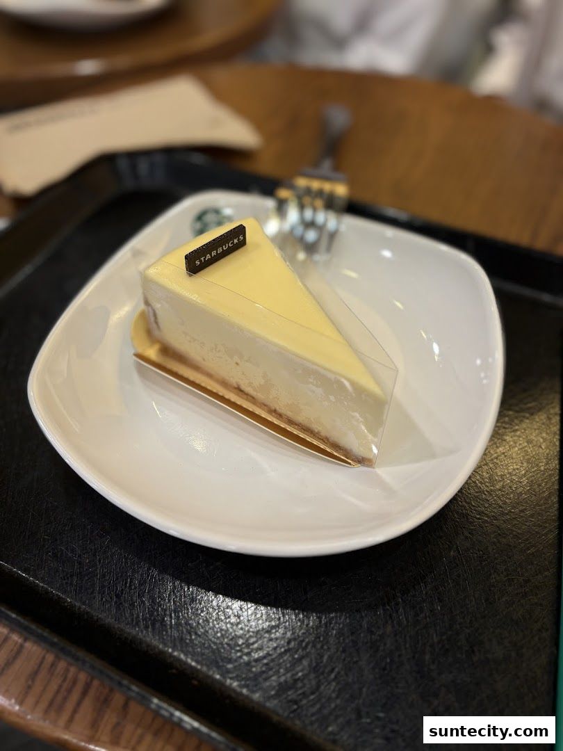 A slice of cheesecake with a Starbucks logo on a white plate.