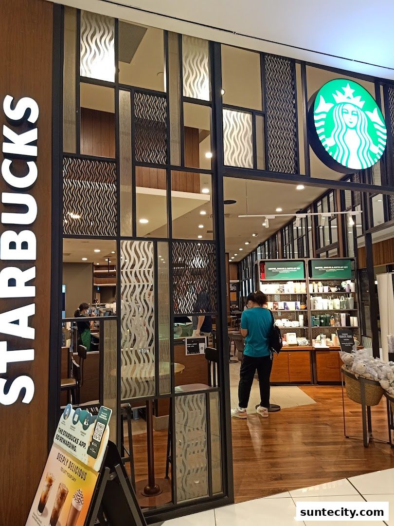 The entrance of a Starbucks store with its iconic logo and merchandise displays.