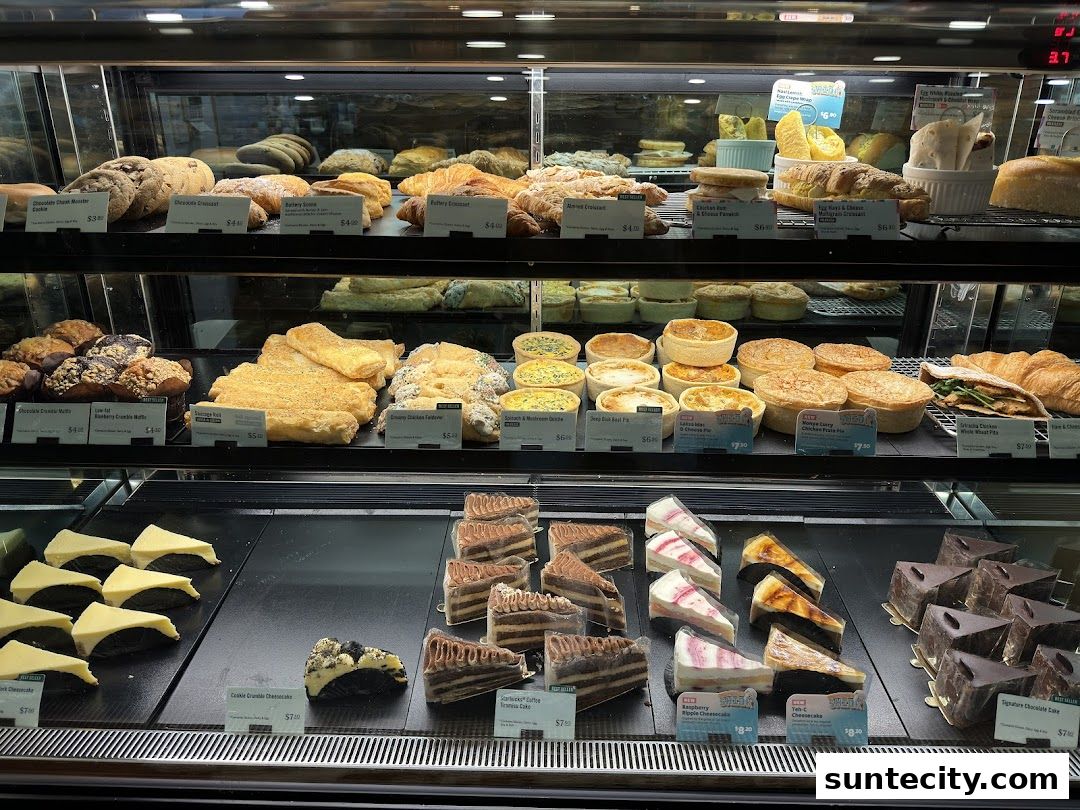 A display case filled with various pastries, cakes, and savory items.