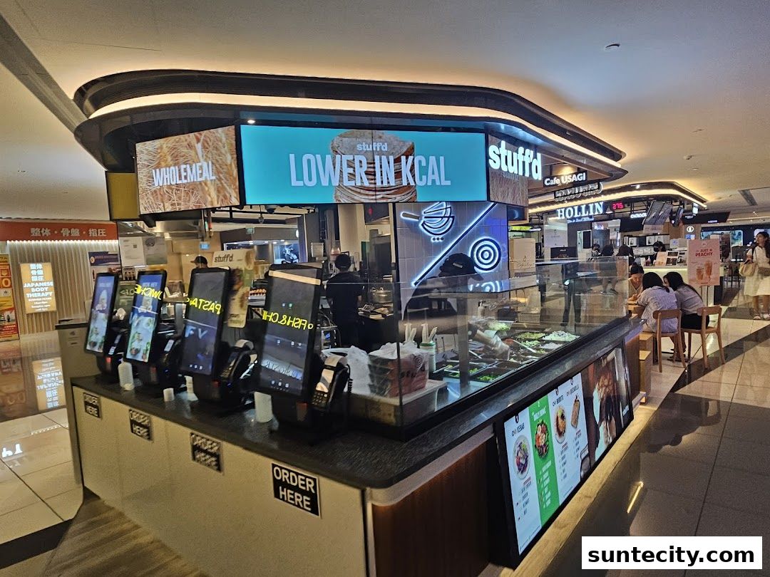 A food stall with digital ordering kiosks and a display of fresh ingredients.