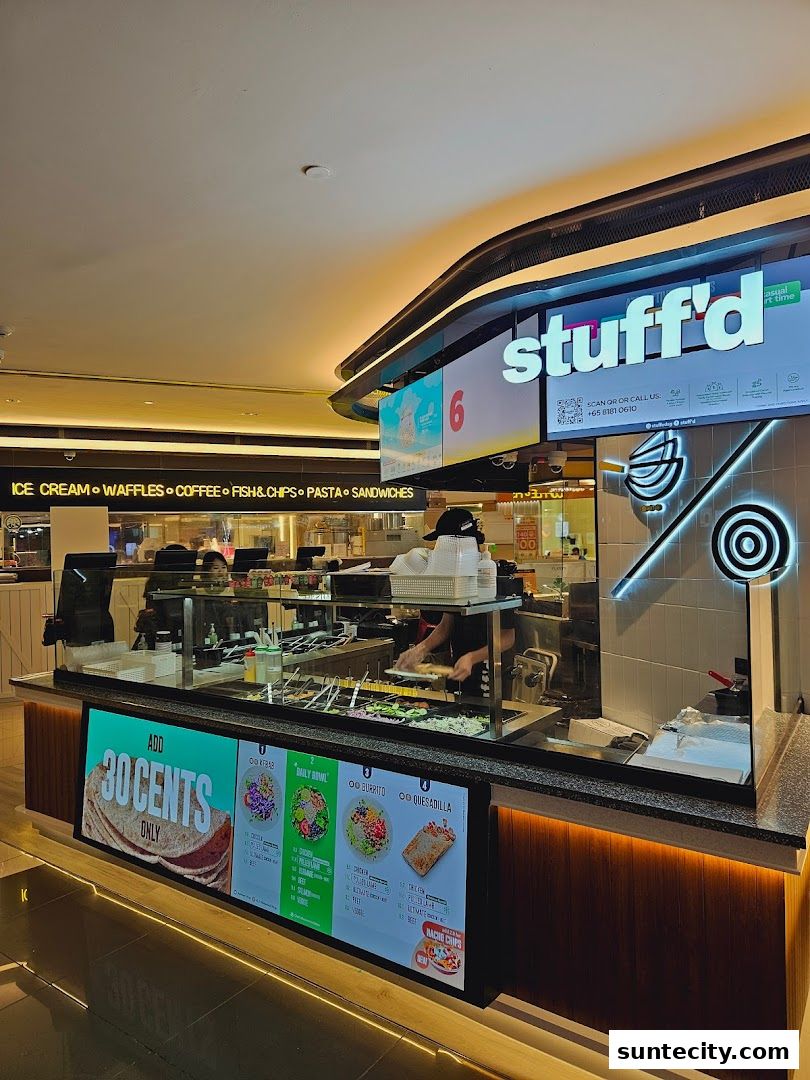 A food stall with a display of food items and a menu board.