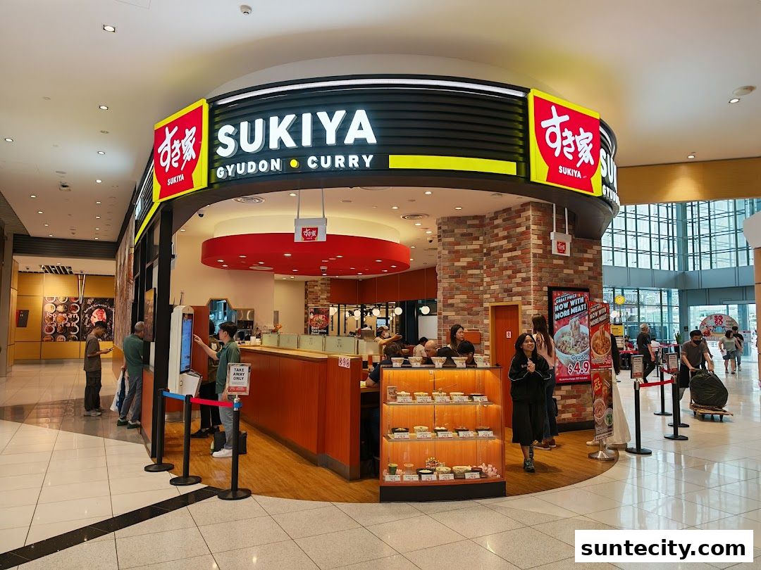 The Sukiya Gyudon Curry shop front with customers ordering and dining inside.