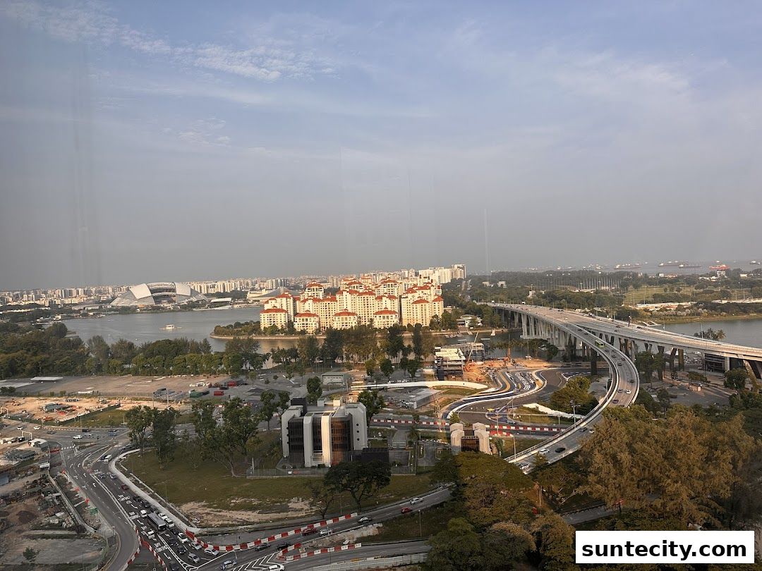 Aerial view of a cityscape with a stadium, residential buildings, and a bridge over water.