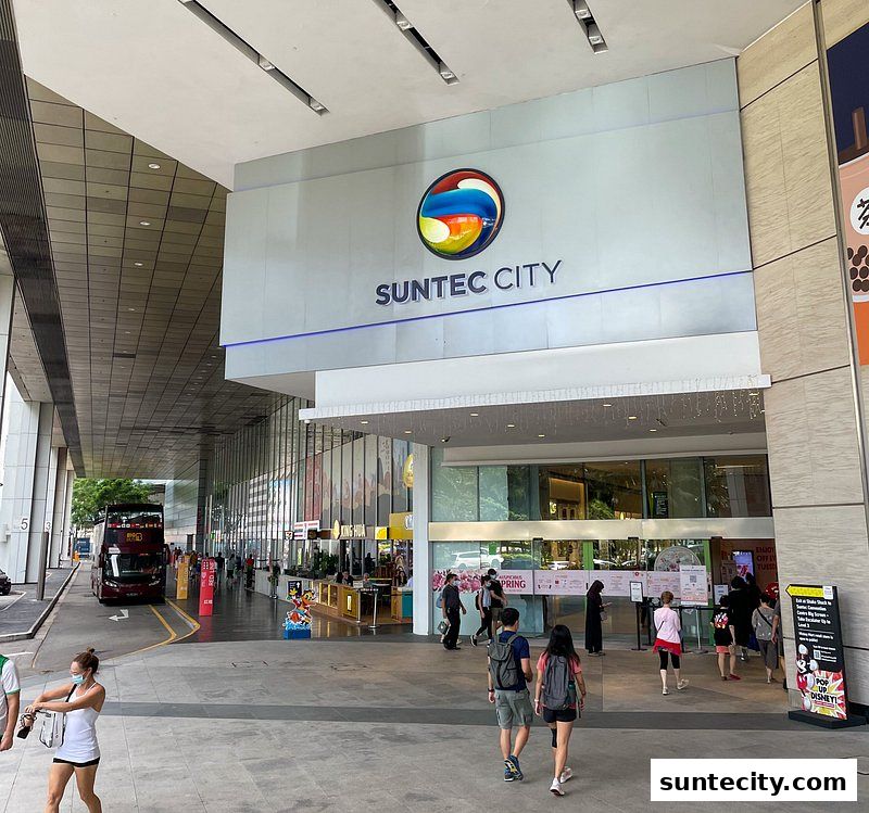 People walking towards the entrance of Suntec City mall with its prominent signage.