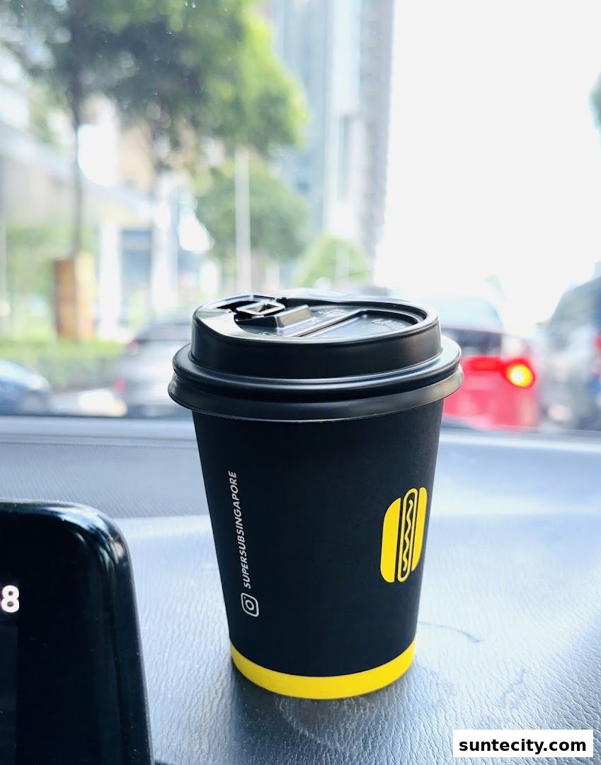 A black coffee cup with the Super Sub logo and Instagram handle.