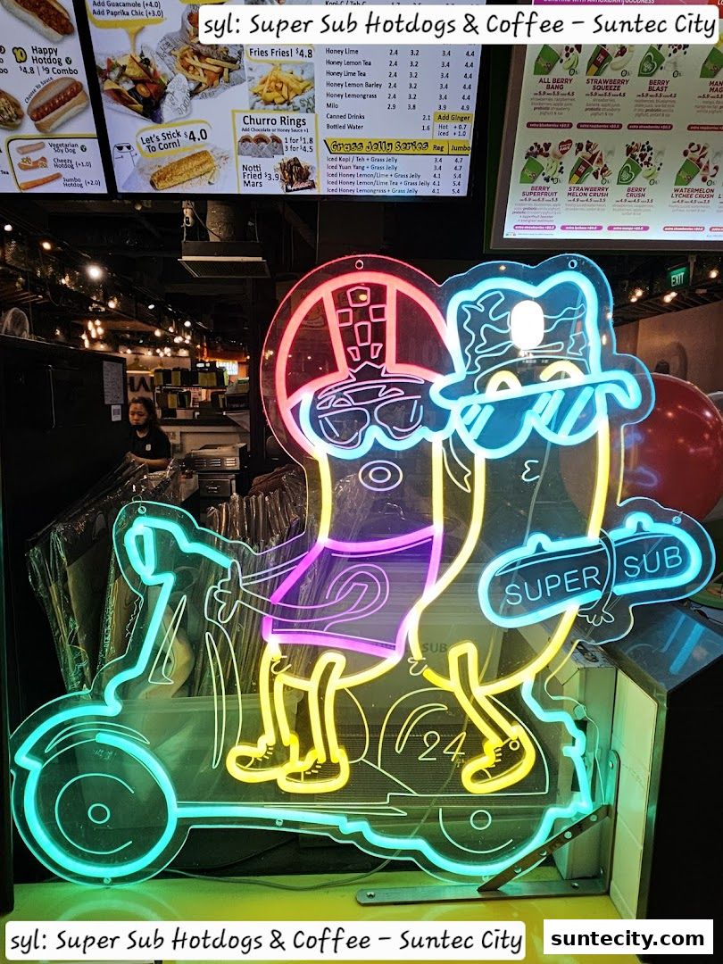 A vibrant neon sign of two hotdogs riding a scooter in front of a shop.