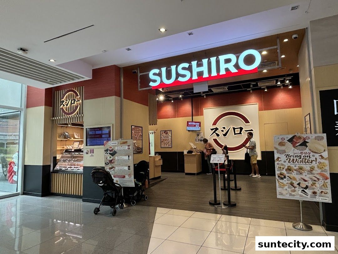 The entrance of Sushiro Suntec City, a Japanese restaurant with a prominent sign and display of food.
