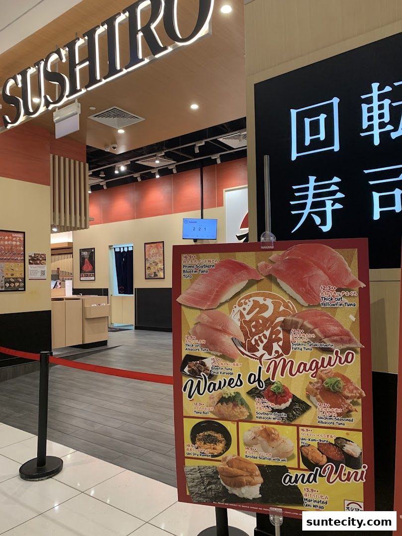 The entrance of Sushiro Suntec City with a promotional poster for tuna and uni dishes.