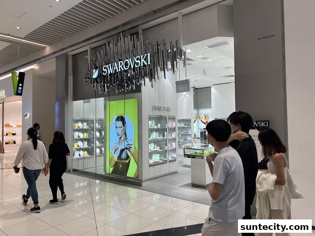 The exterior of a Swarovski jewelry store with a large display window and people walking by.