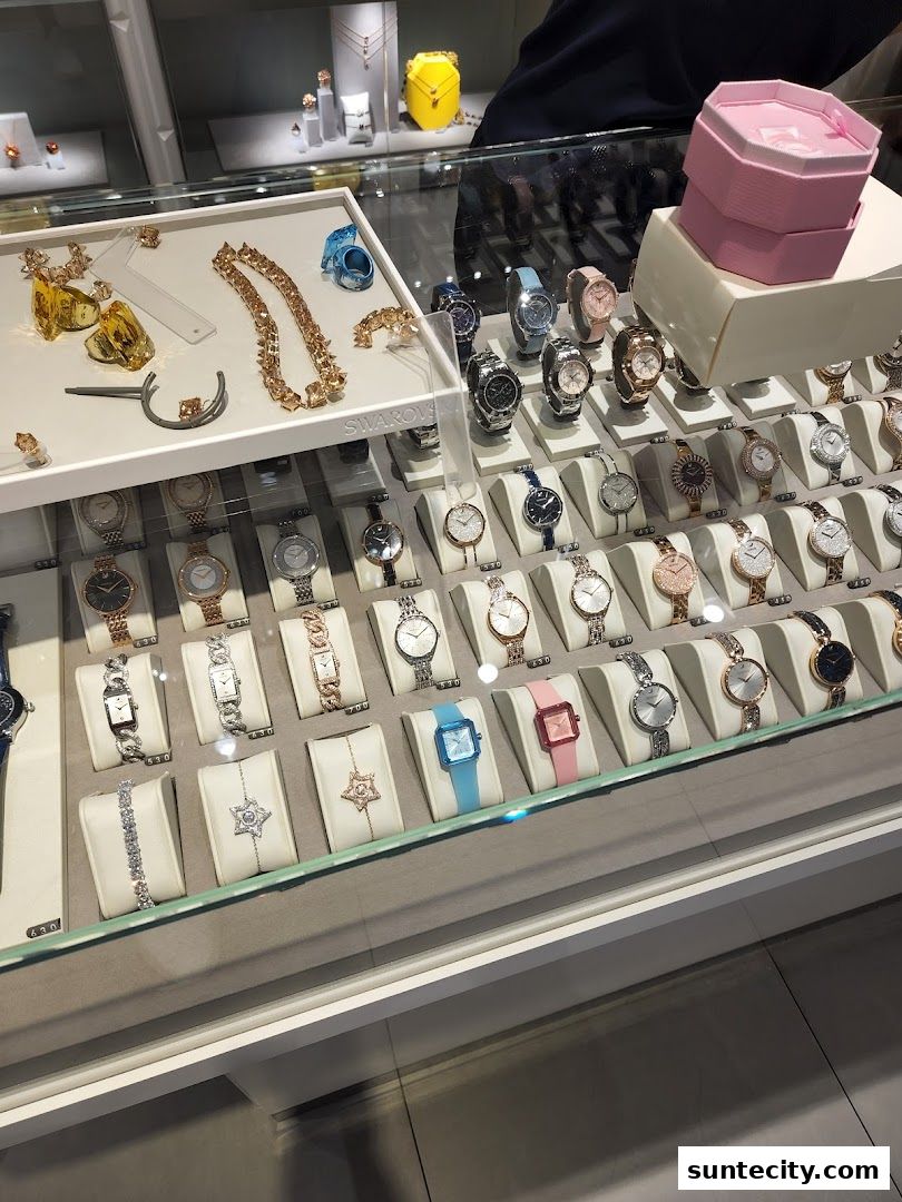 A display case filled with Swarovski watches and jewelry, featuring sparkling designs and elegant presentation.