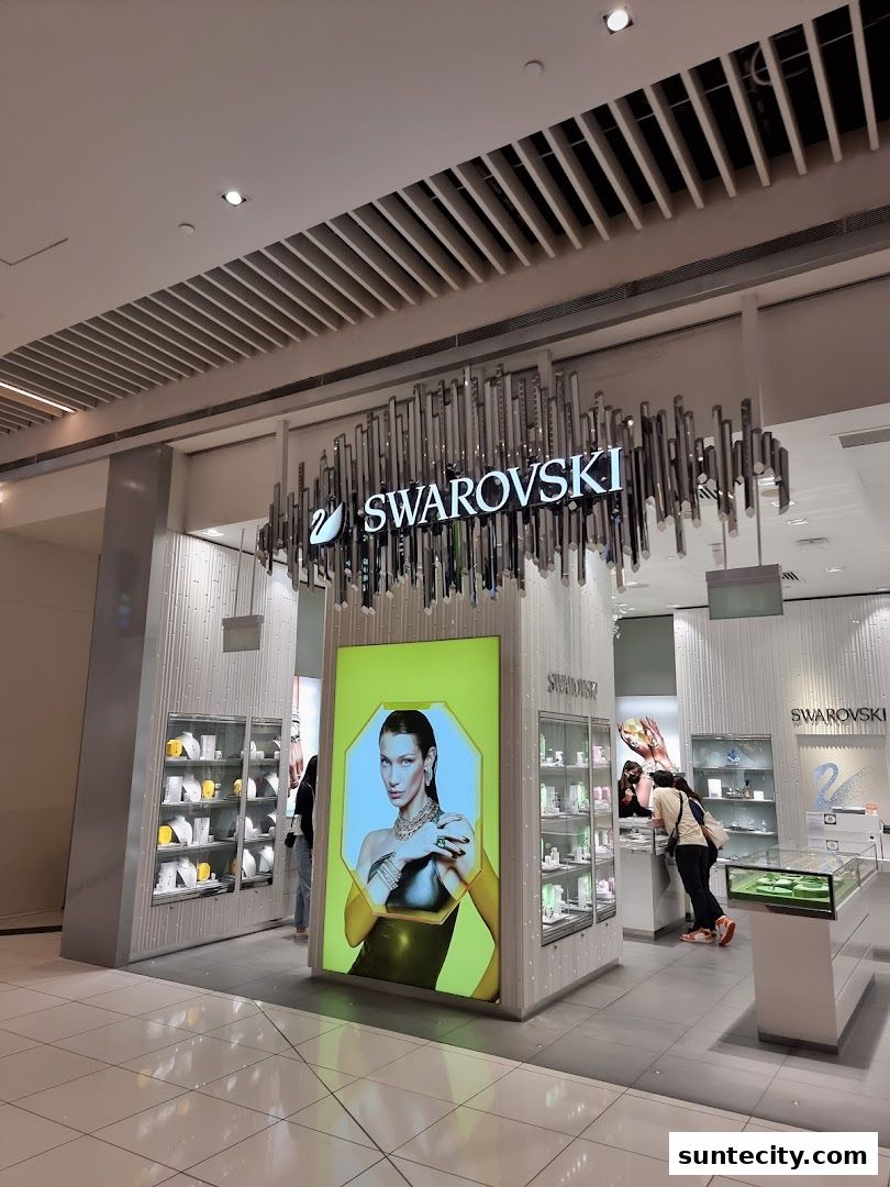 The exterior of a Swarovski jewelry store with illuminated displays and a large advertisement.