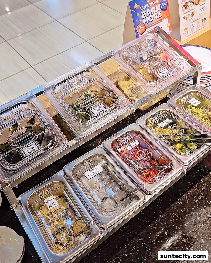 A selection of fresh toppings and condiments displayed in clear containers at a food establishment.