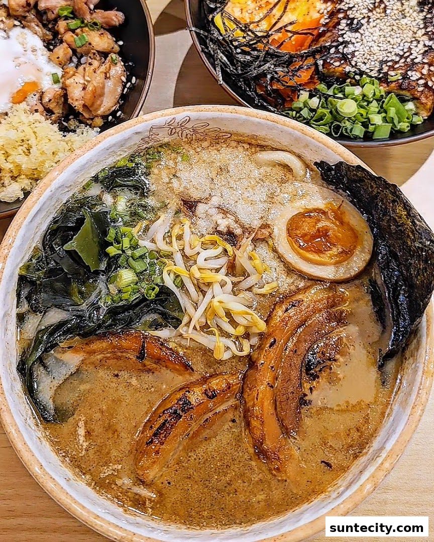 A close-up of a steaming bowl of ramen with pork, egg, seaweed, and bean sprouts.