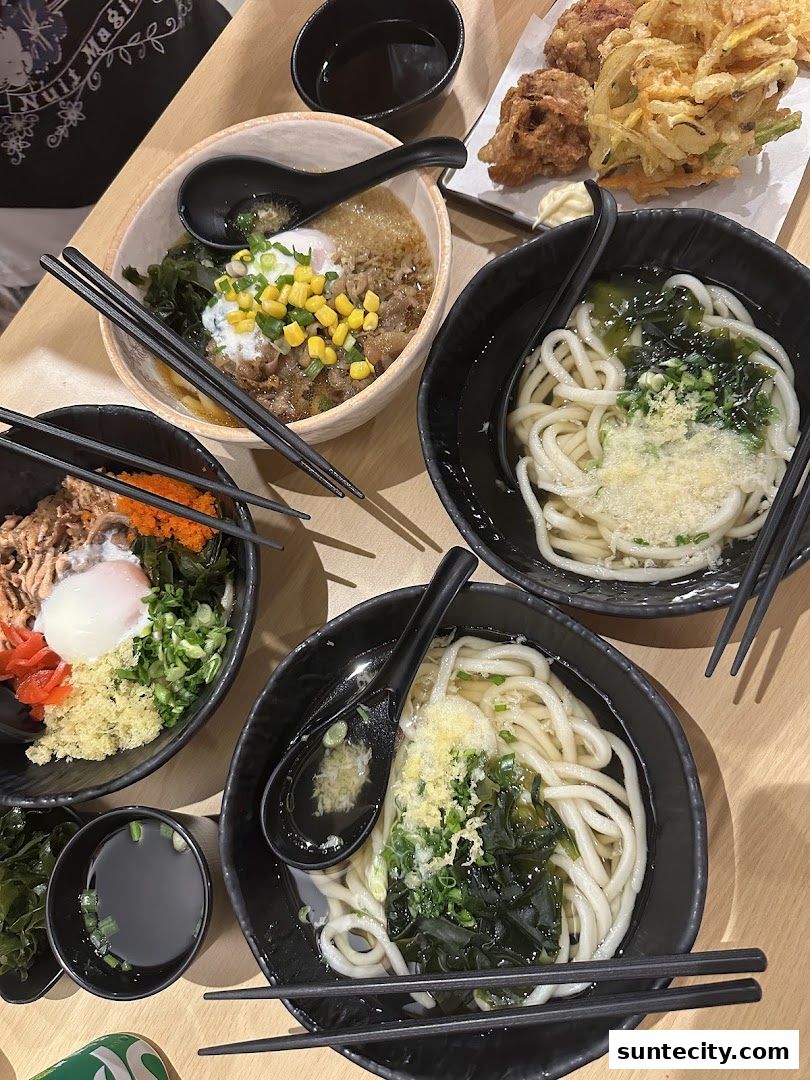A table laden with delicious bowls of udon noodles and tempura.