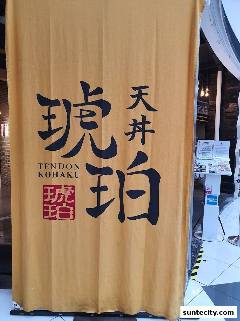 A yellow fabric banner with Japanese characters and the shop name 'Tendon Kohaku'.
