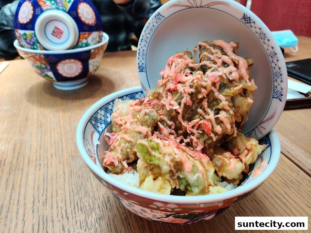 A close-up of a delicious tempura donburi dish served in a decorative bowl.