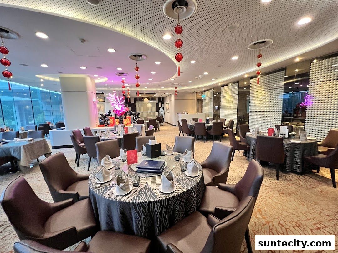 Elegant dining room with round tables set for a meal, decorated with red lanterns.