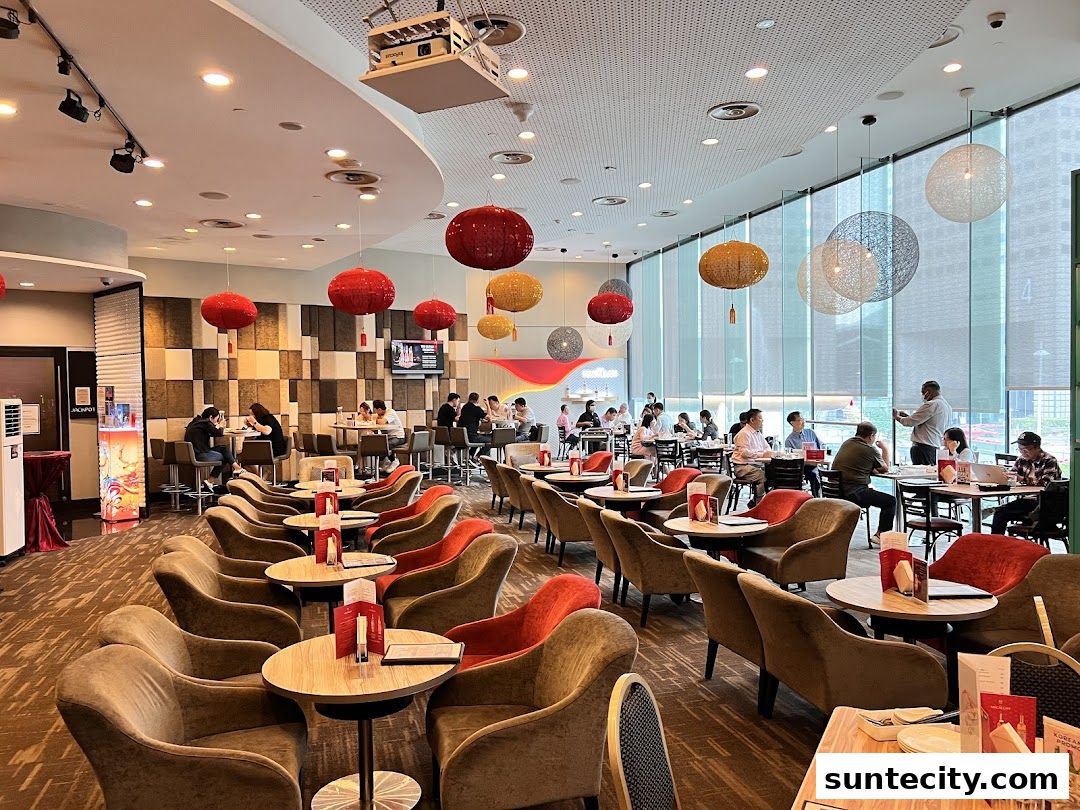 Interior view of a spacious bistro with many patrons seated at tables and a large window.