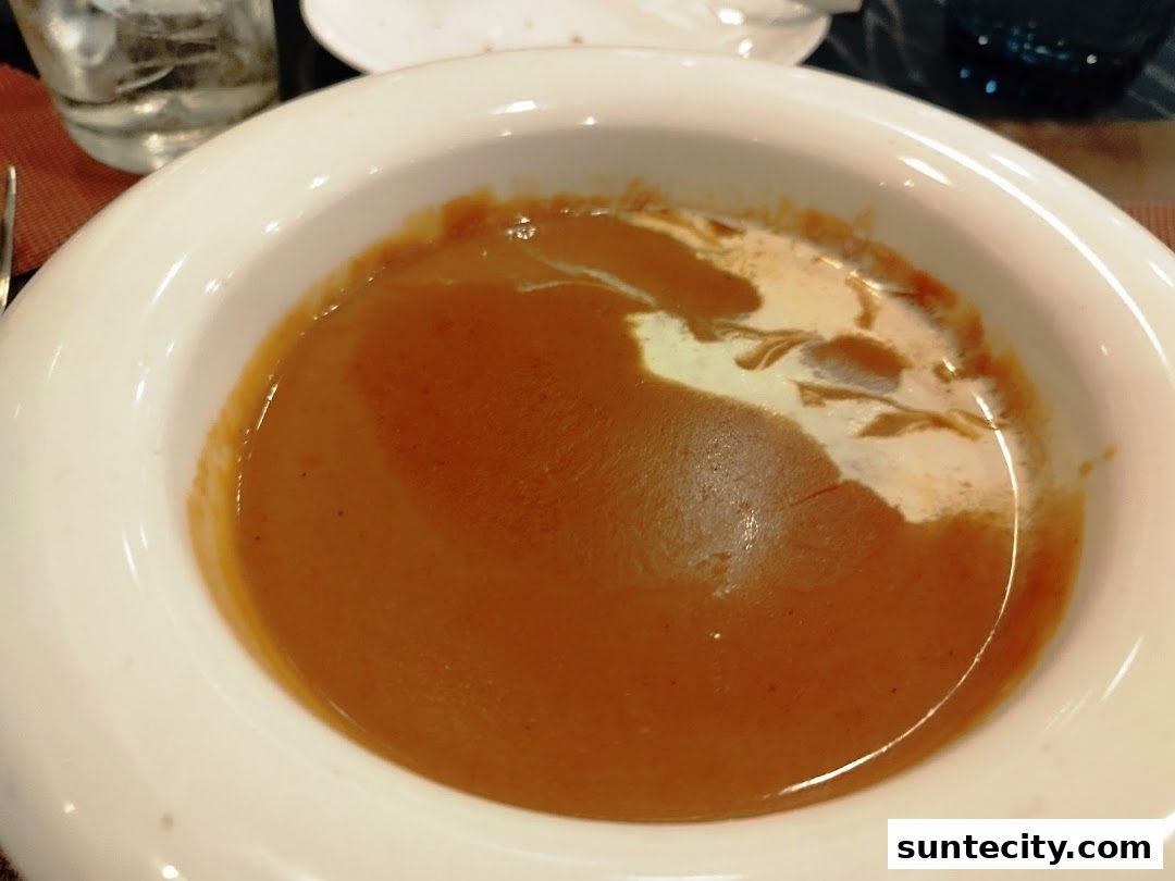 A close-up shot of a bowl of creamy tomato soup with a swirl of cream.
