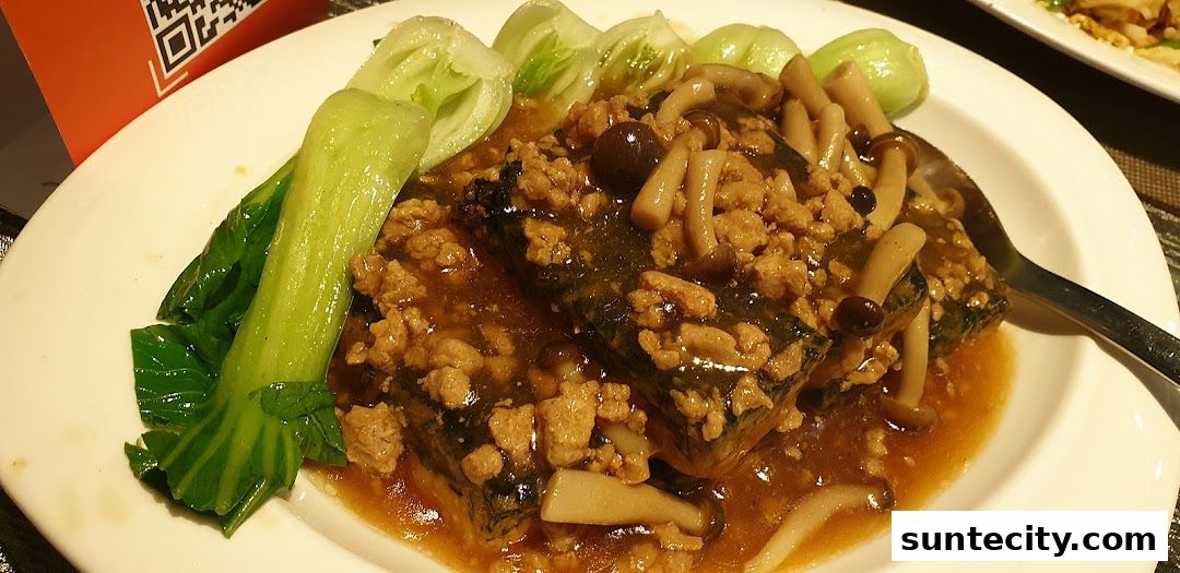 A plate of braised tofu with minced meat, mushrooms, and bok choy.