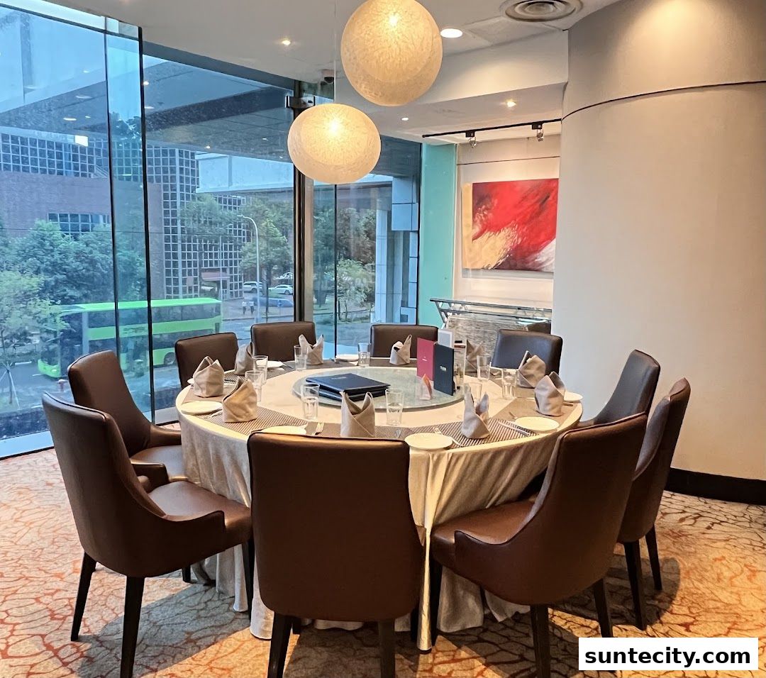 A round dining table set for a meal with chairs and a view of the city outside.