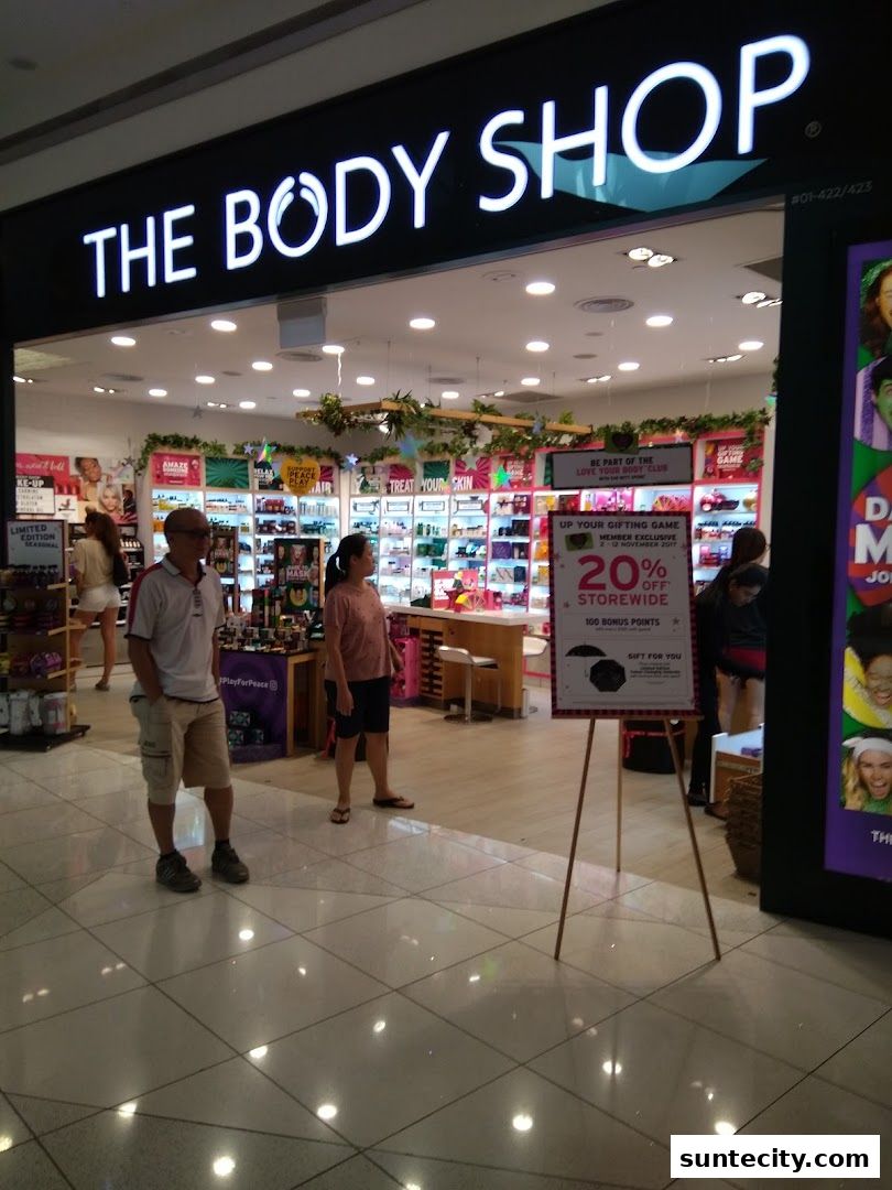 The Body Shop storefront with products displayed inside and customers browsing.