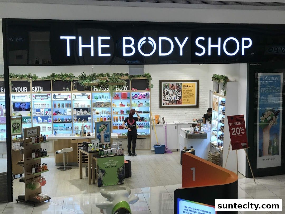 The Body Shop storefront with illuminated signage and displays of skincare products.