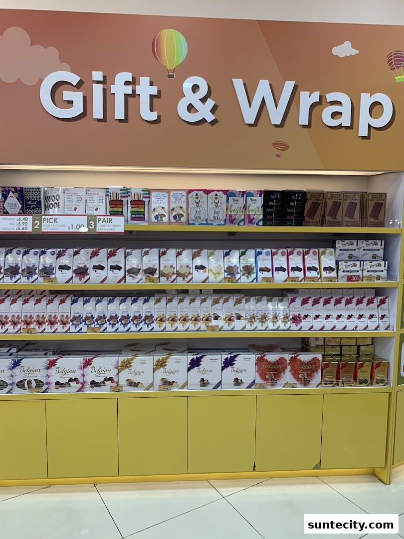 Shelves stocked with assorted chocolates and gift cards under a 'Gift & Wrap' sign.