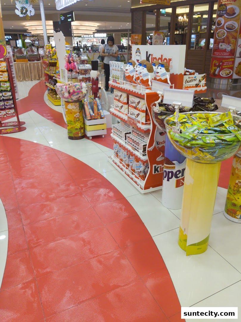 A display of Kinder chocolate products and other candies in a brightly lit store.