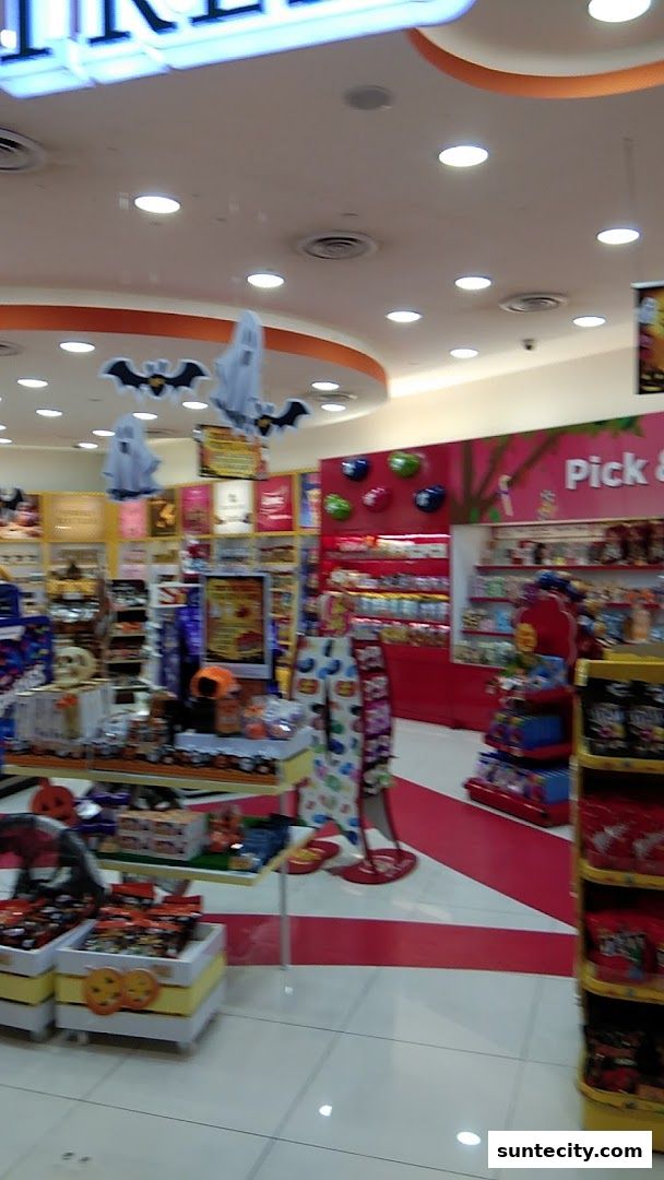 Interior view of a candy store with Halloween decorations and various sweets on display.