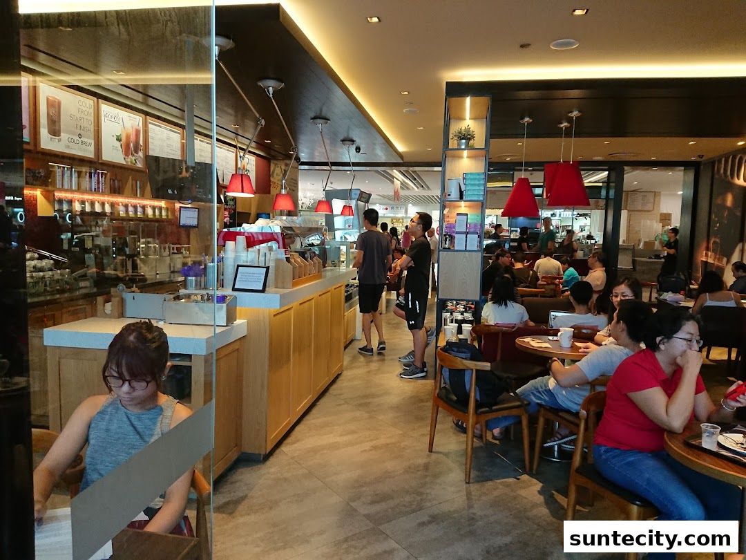Interior view of a busy Coffee Bean Tea Leaf cafe with customers seated and ordering.