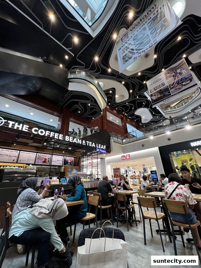 People enjoying coffee and tea at The Coffee Bean & Tea Leaf in a modern shopping mall.