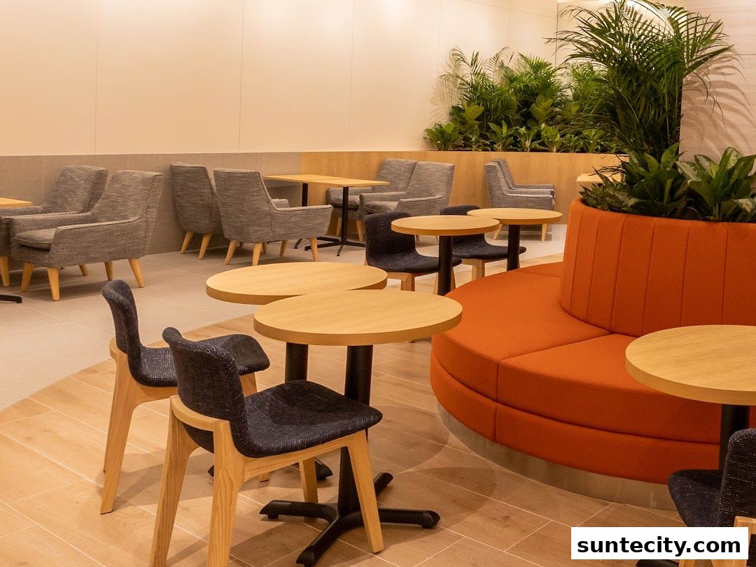 Interior shot of a coffee shop with modern seating, tables, and lush greenery.