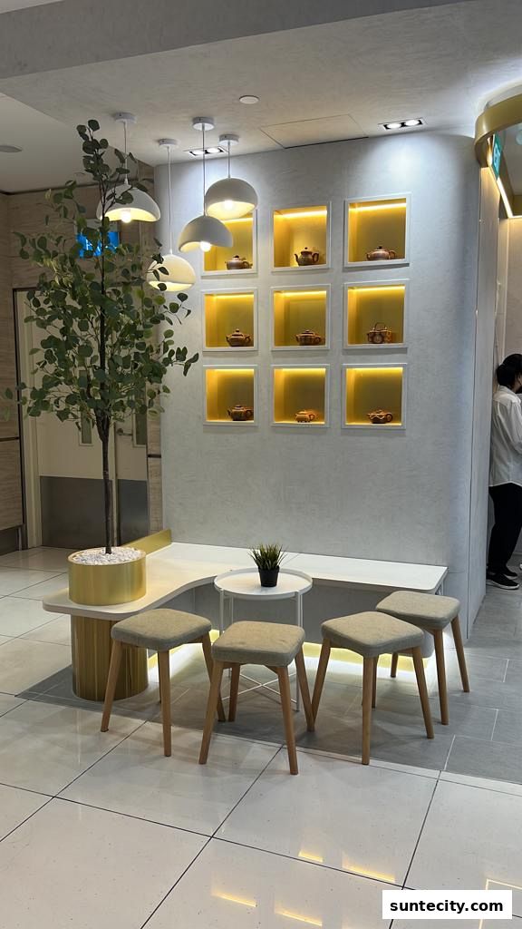 A modern seating area with stools, a bench, and decorative teapots displayed on a wall.