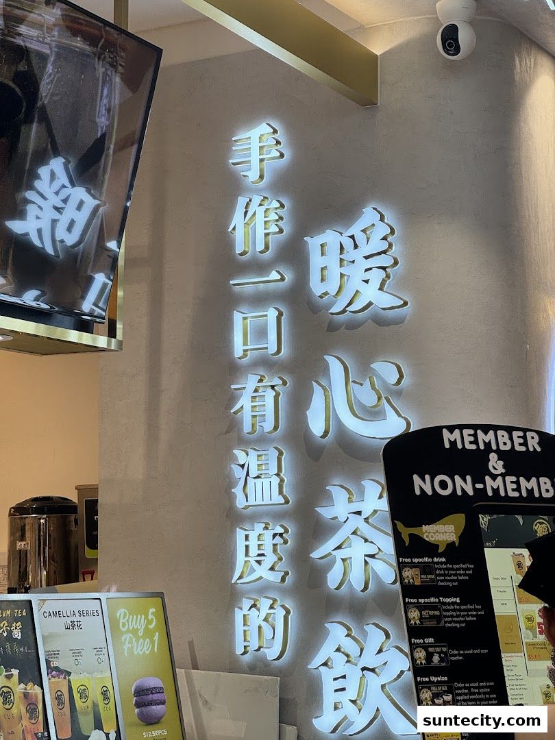 A shop front with illuminated Chinese characters and a menu board displaying promotions.