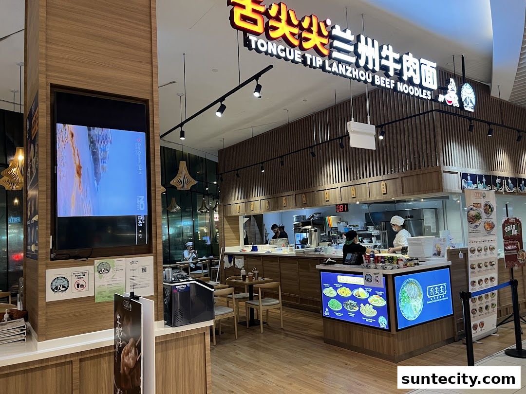 Interior view of a Lanzhou Beef Noodles shop with a visible kitchen and digital menu displays.