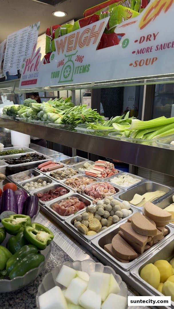 A display of fresh ingredients for hot pot, including vegetables, meats, and meatballs.