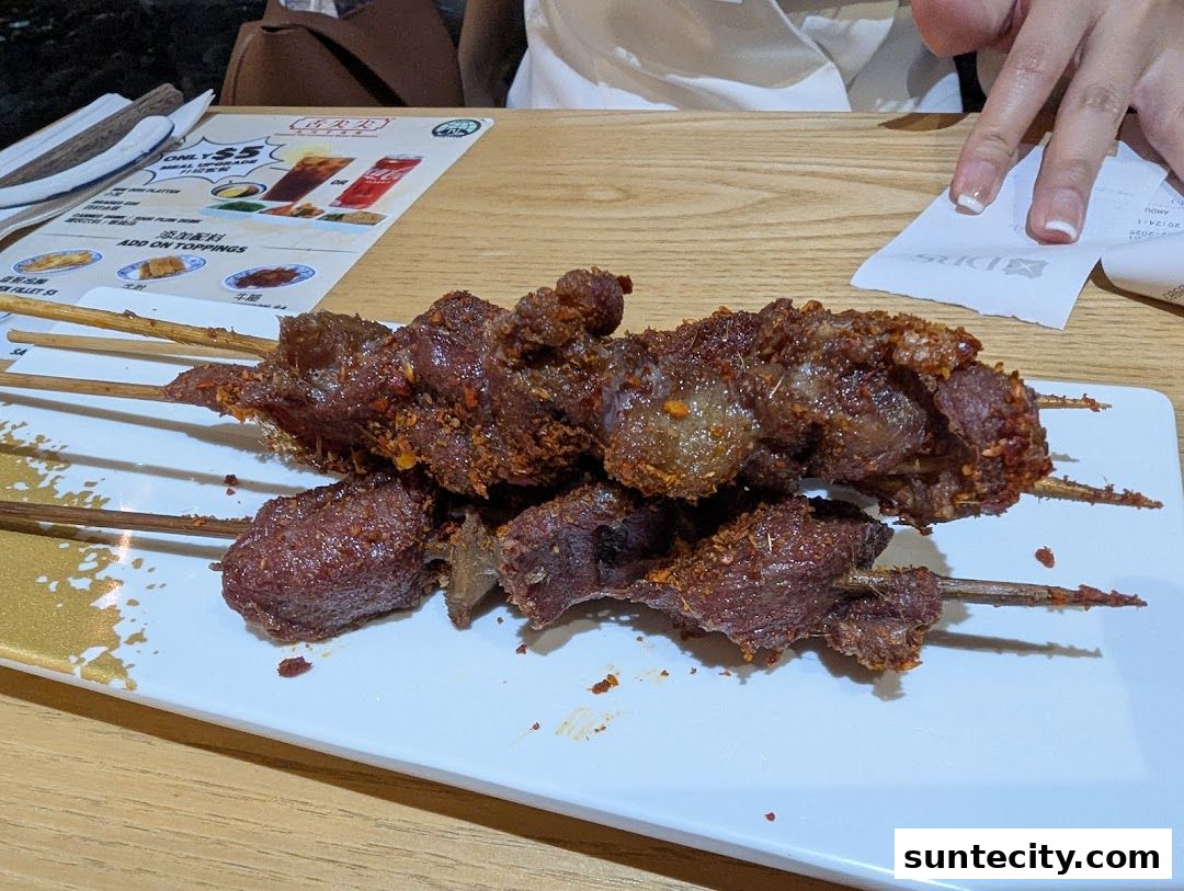A plate of grilled meat skewers seasoned with spices, served on a white plate.