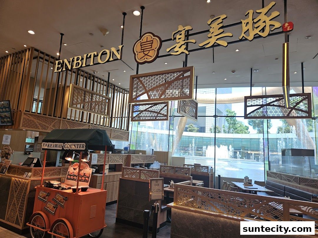 Interior view of Tonkatsu ENbiton restaurant with seating, takeaway counter, and large windows overlooking a fountain.