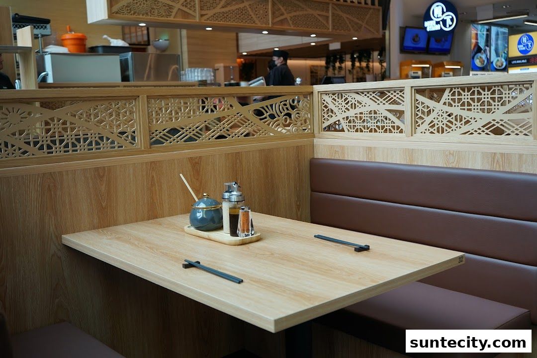 A clean dining table setting at Tonkatsu ENbiton with chopsticks and condiments.