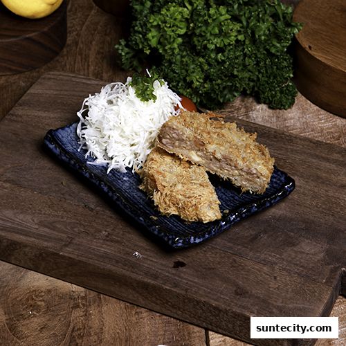 A close-up of a delicious fried dish with shredded cabbage on a blue plate.